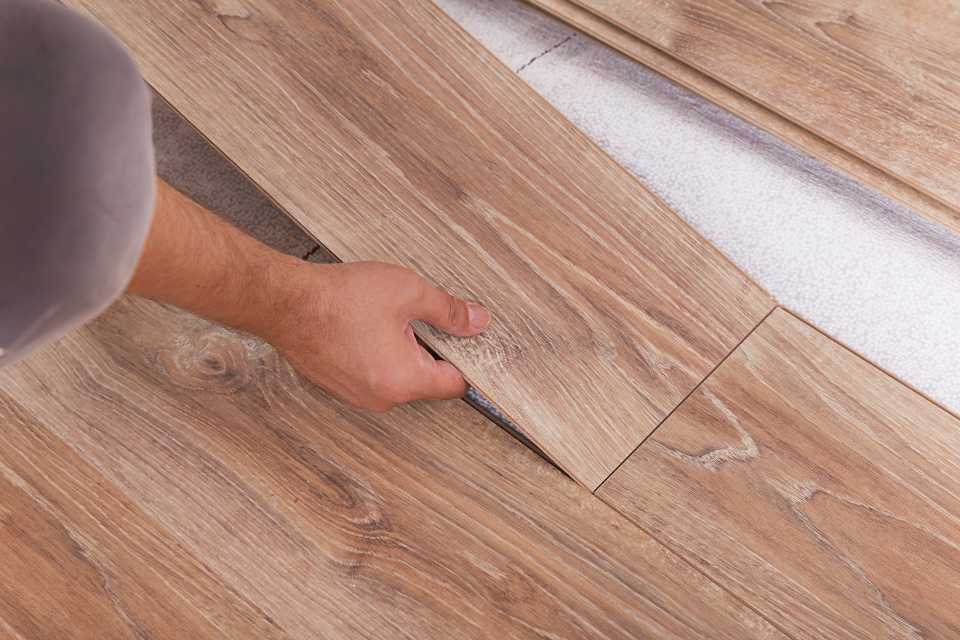 professional installer laying down luxury vinyl flooring